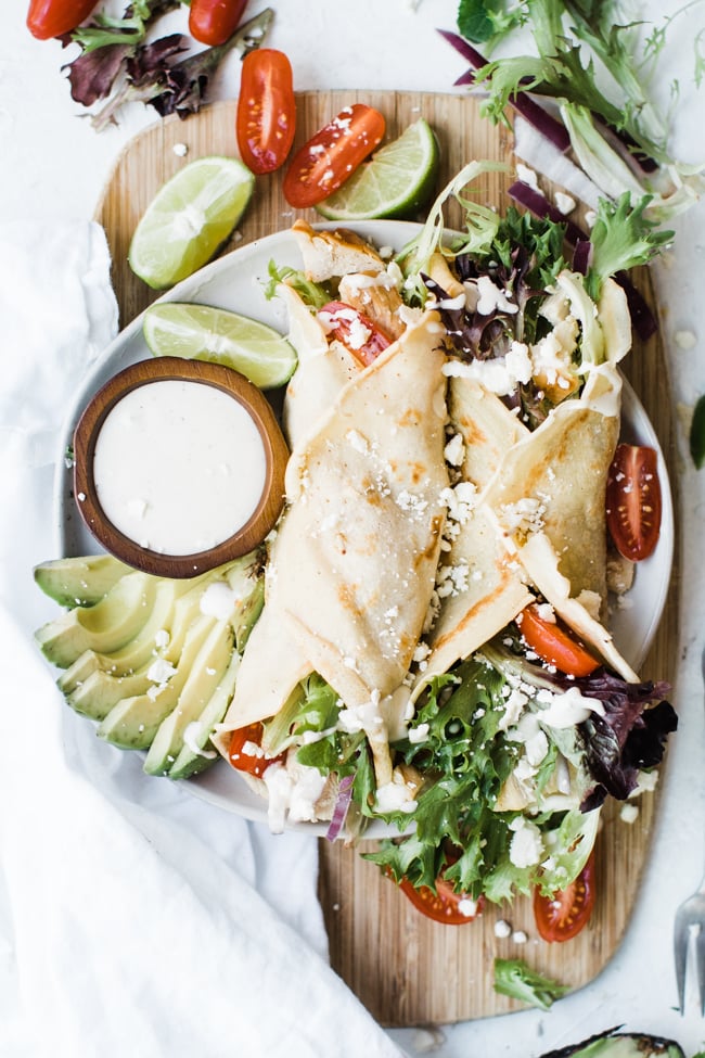 two crepes rolled up filled with lettuce and chicken and dressing