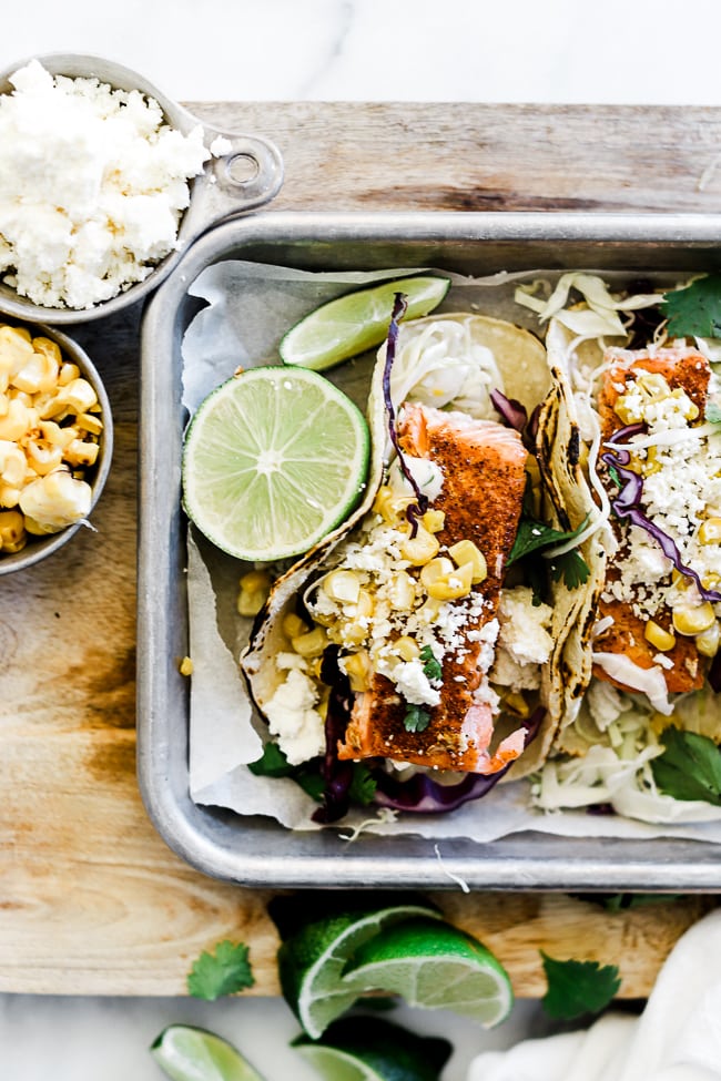 A close up of blacked fish tacos on a metal baking tray.