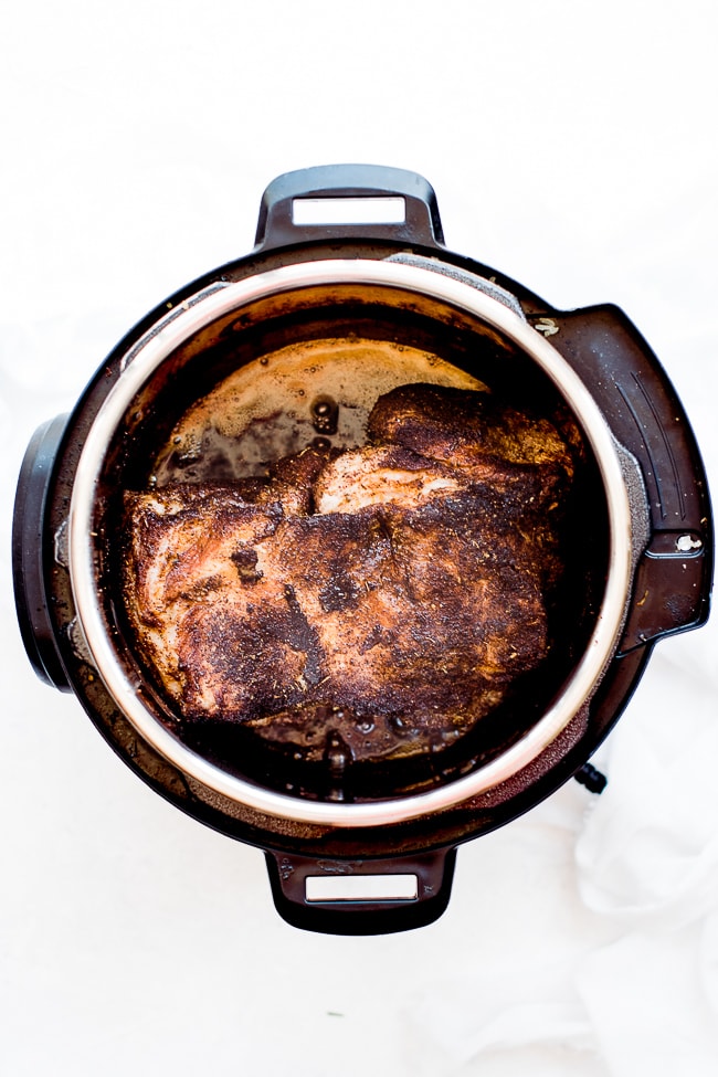 pork butt in instant pot being browned on both sides