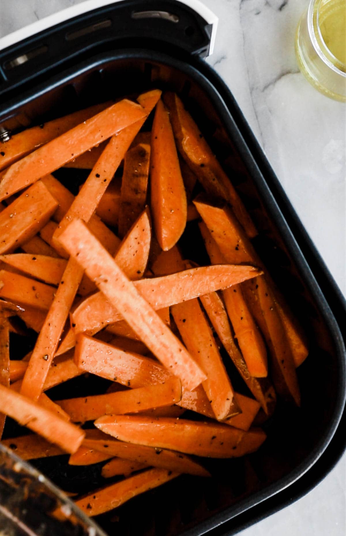 sweet potato fries in air fryer basket.