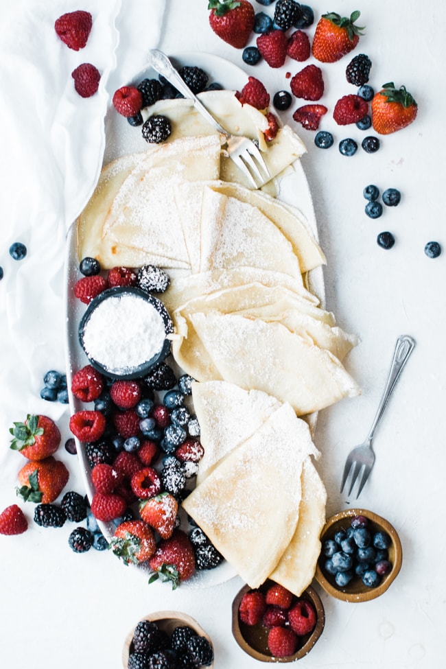 fluffy crepes dusted with powdered sugar and berries