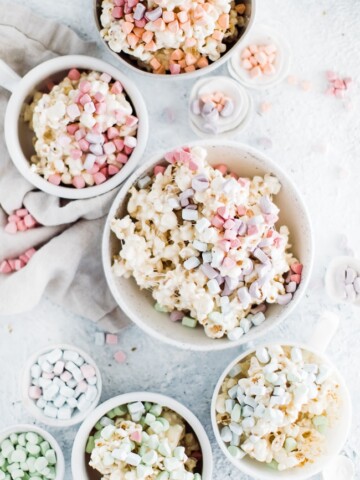 five bowls of various sizes with marshmallow popcorn topped with cereal marshmallow