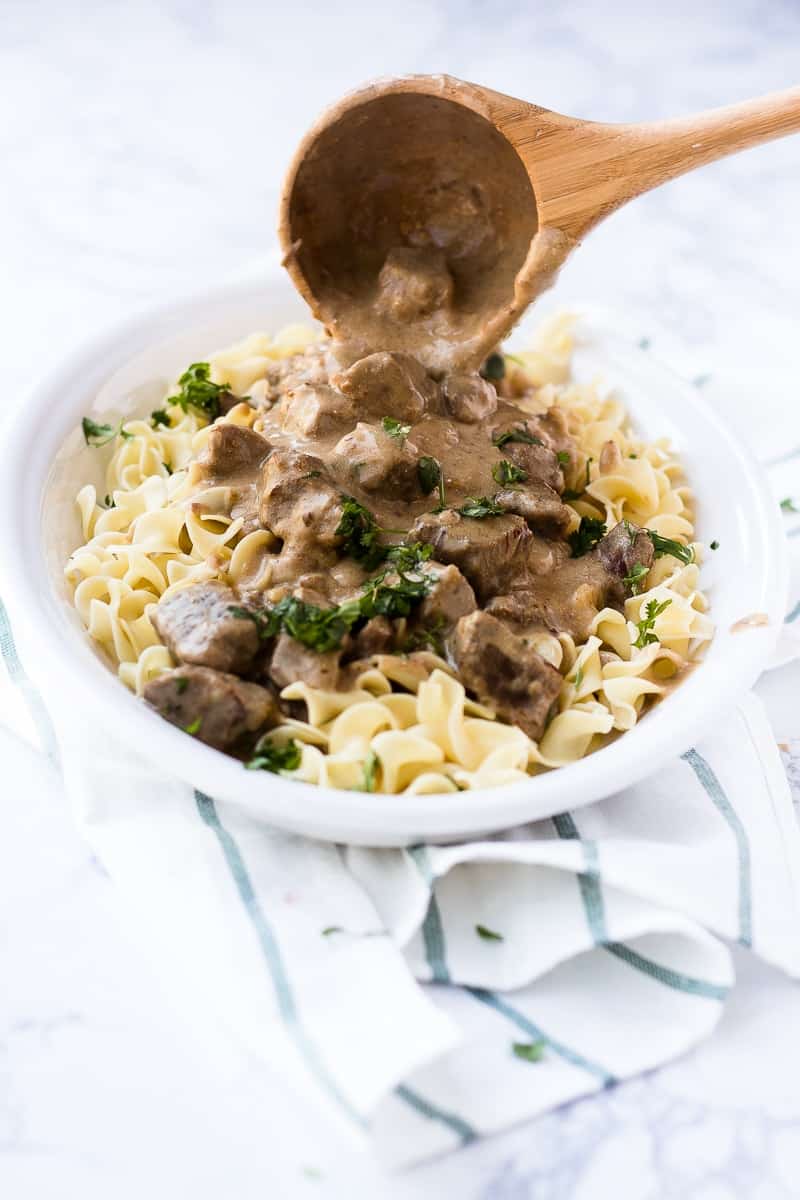 Beef Stroganoff Recipe with wooden spoon pouring sauce over it