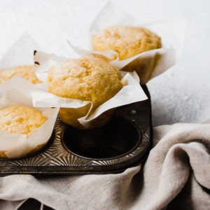 Easy cornbread muffins in a metal muffin tin atop a grey napkin.