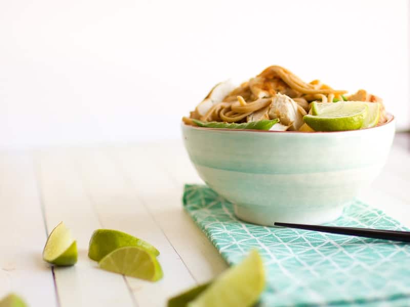 Pasta with Peanut Sauce with lime wedges nearby and chopsticks