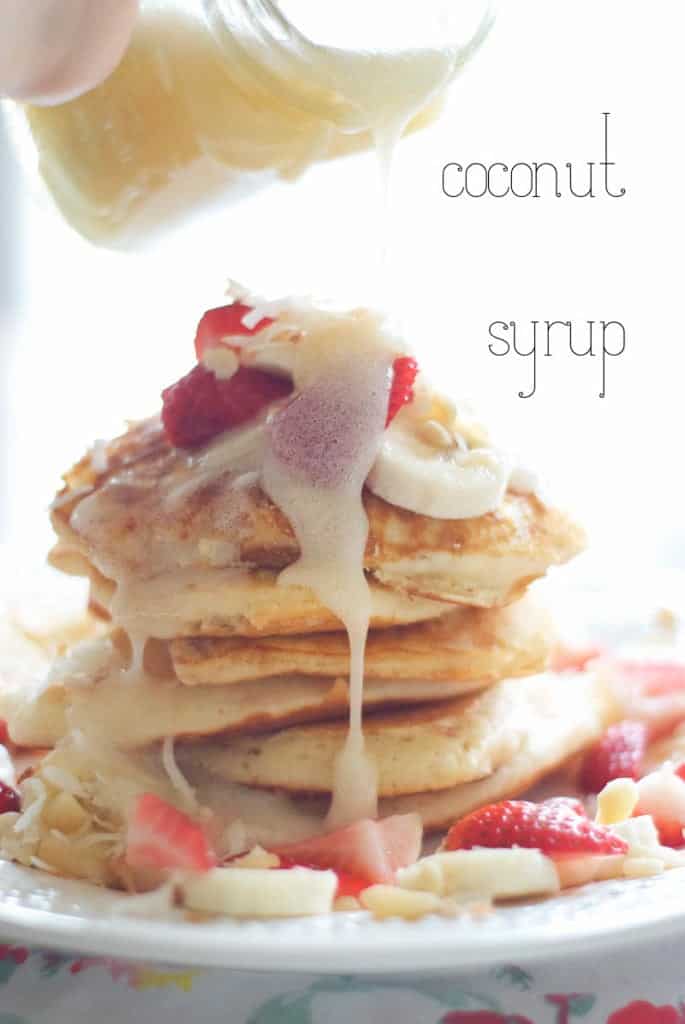 A close up of a stack of Tropical Pancakes with a Coconut Syrup getting poured on top