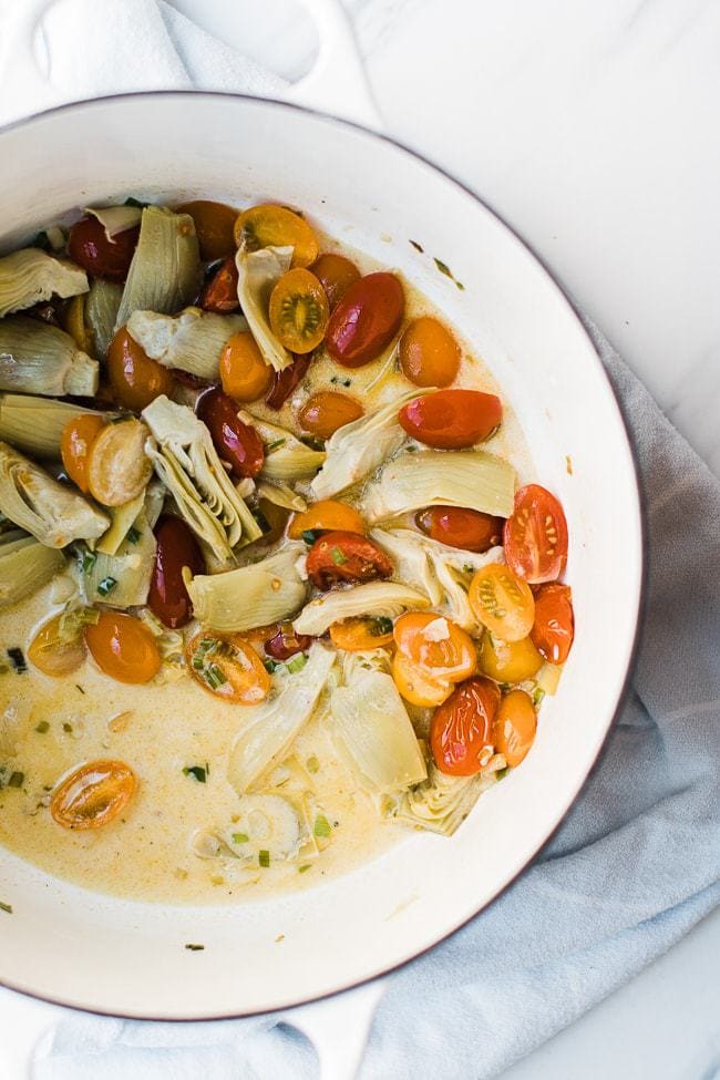 tomatoes, artichokes and cream sauce in pan