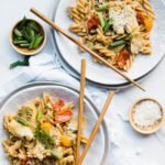 two plates of creamy artichoke pasta with chopsticks