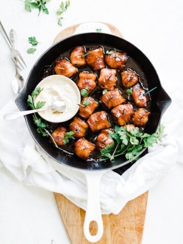 Bacon wrapped water chestnuts in a cast iron skillet.