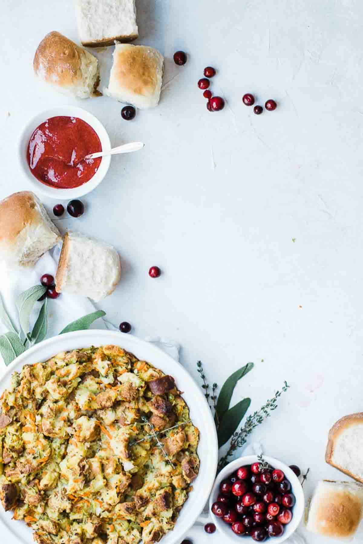 Stuffing in a bowl with rolls, cranberries and homemade jam.