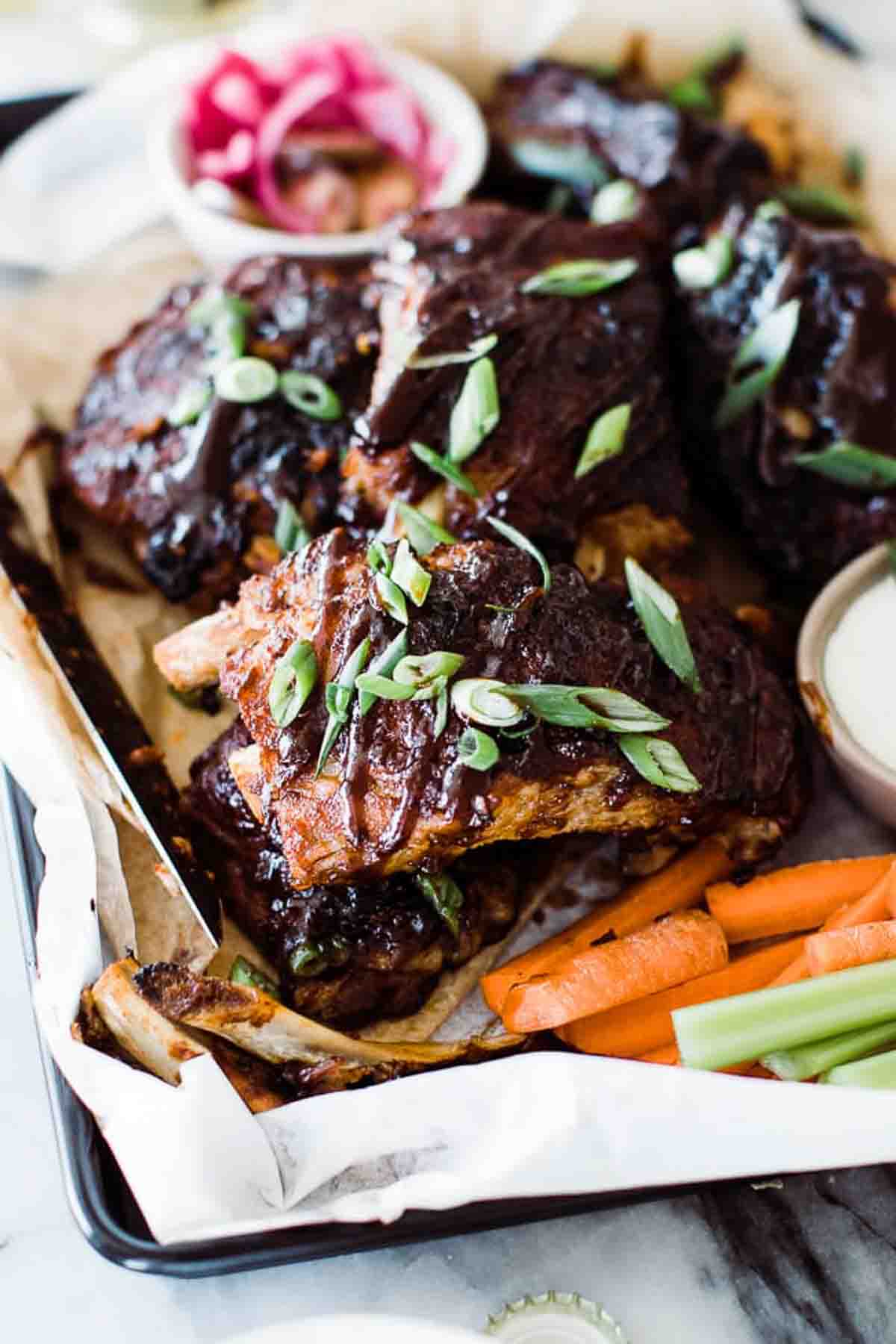 BBQ ribs in the instant pot on a tray with sides.
