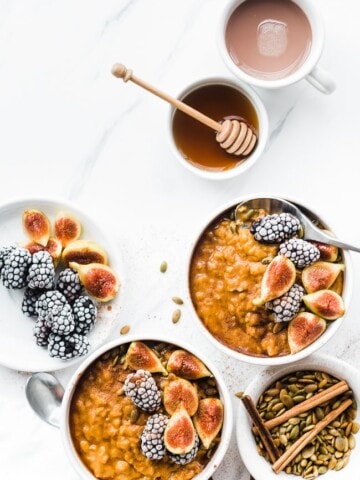 Pumpkin Pie Oatmeal in white bowls topped with blackberries and figs.