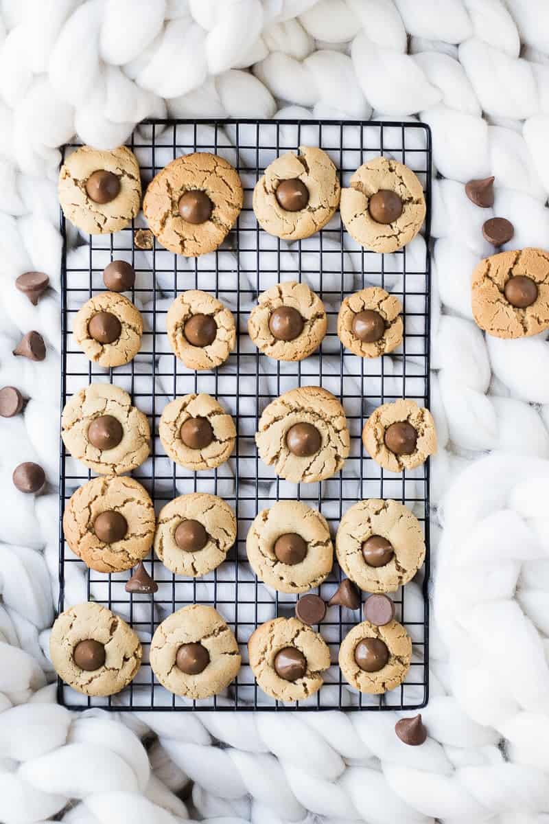 Peanut Butter Blossoms Cookies on a black cooling rack with cosy fabric in the background