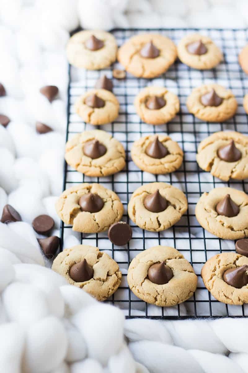 Peanut Butter Blossoms Cookies on a cooling rack with chocolate chips