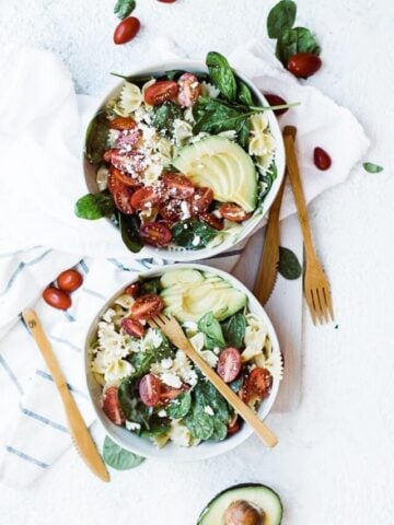 two bowls of healthy bow tie pasta with bamboo silverware