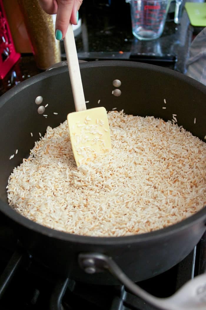 raw rice being cooked golden brown