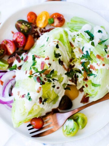 wedge salad with blue cheese dressing, bacon, herbs and cherry tomatoes