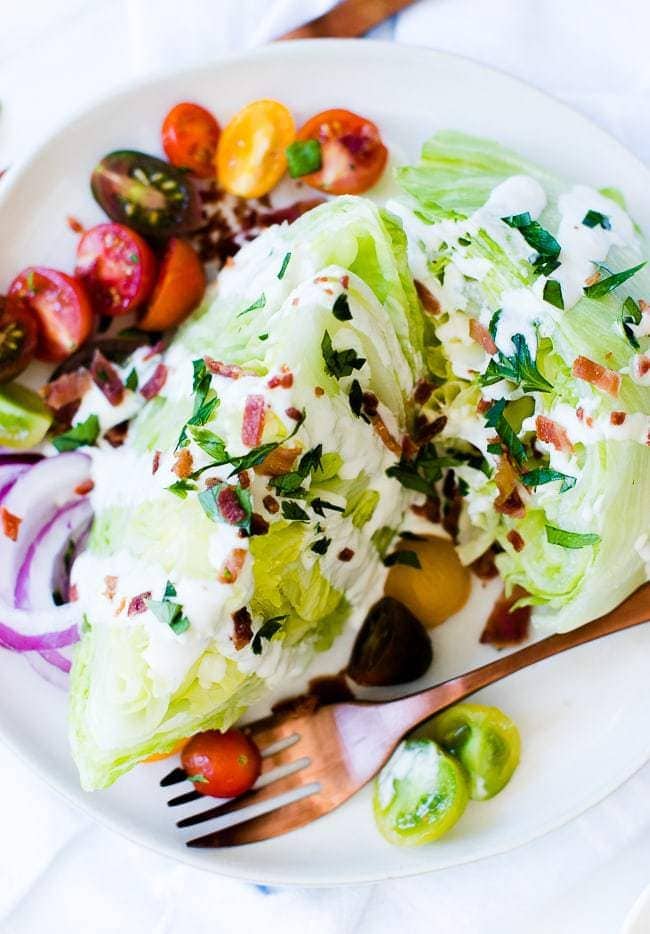 wedge salad with blue cheese dressing, bacon, herbs and cherry tomatoes