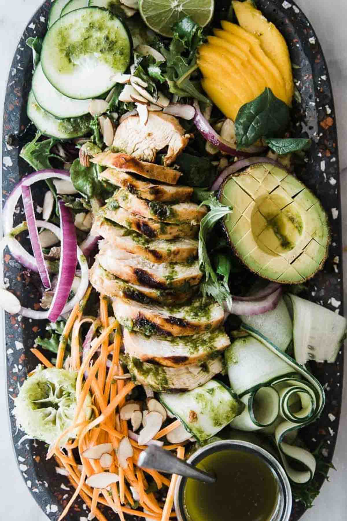 Garlic lime chicken sliced and served up on top of a salad.