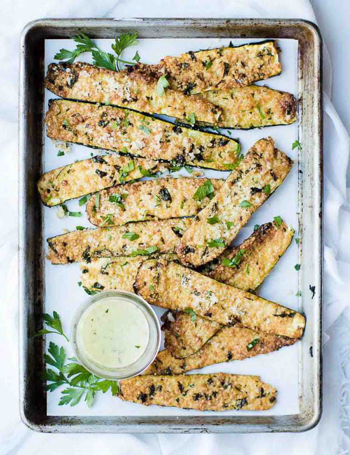 Baked parmesan crusted zucchini on a baking sheet.