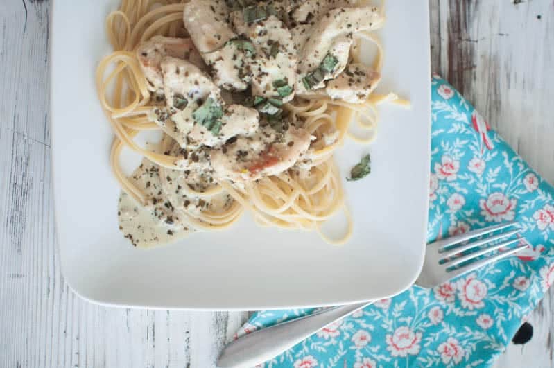 creamy tuscan chicken pasta on plate with fork nearby