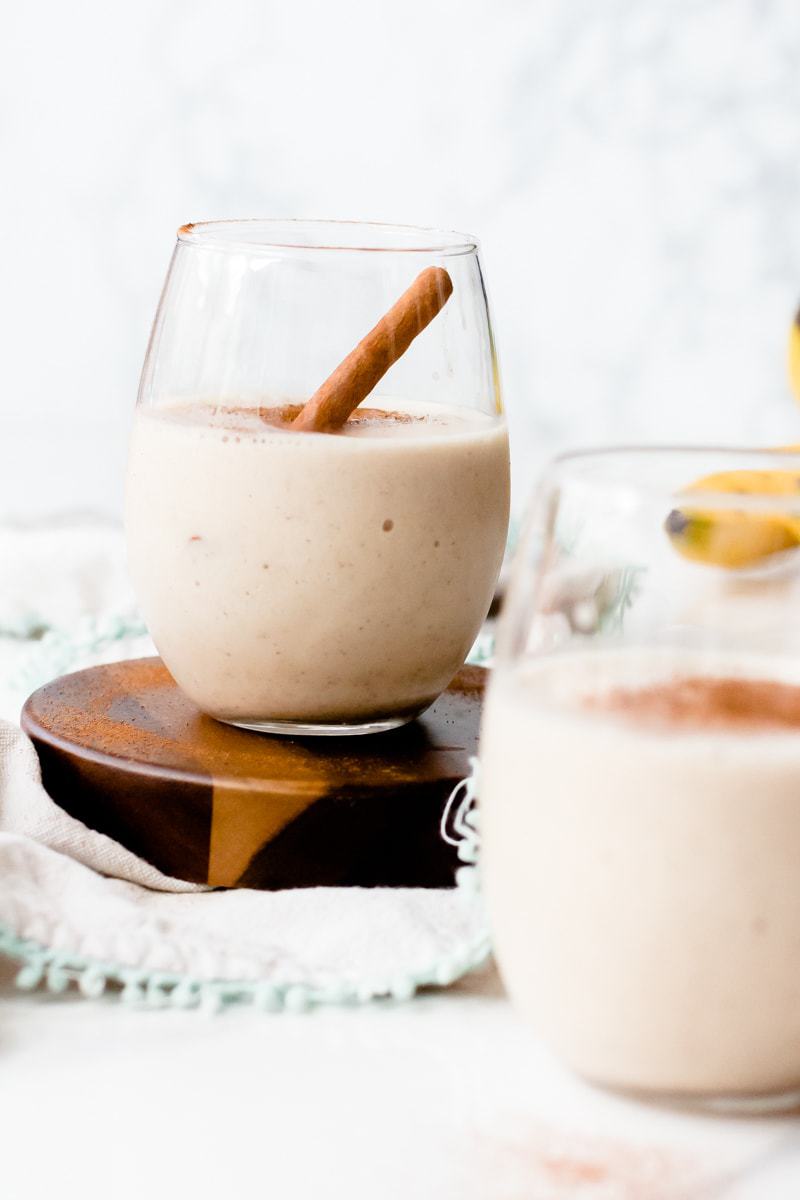 Snickerdoodle Protein Shake in a glass with a cinnamon stick