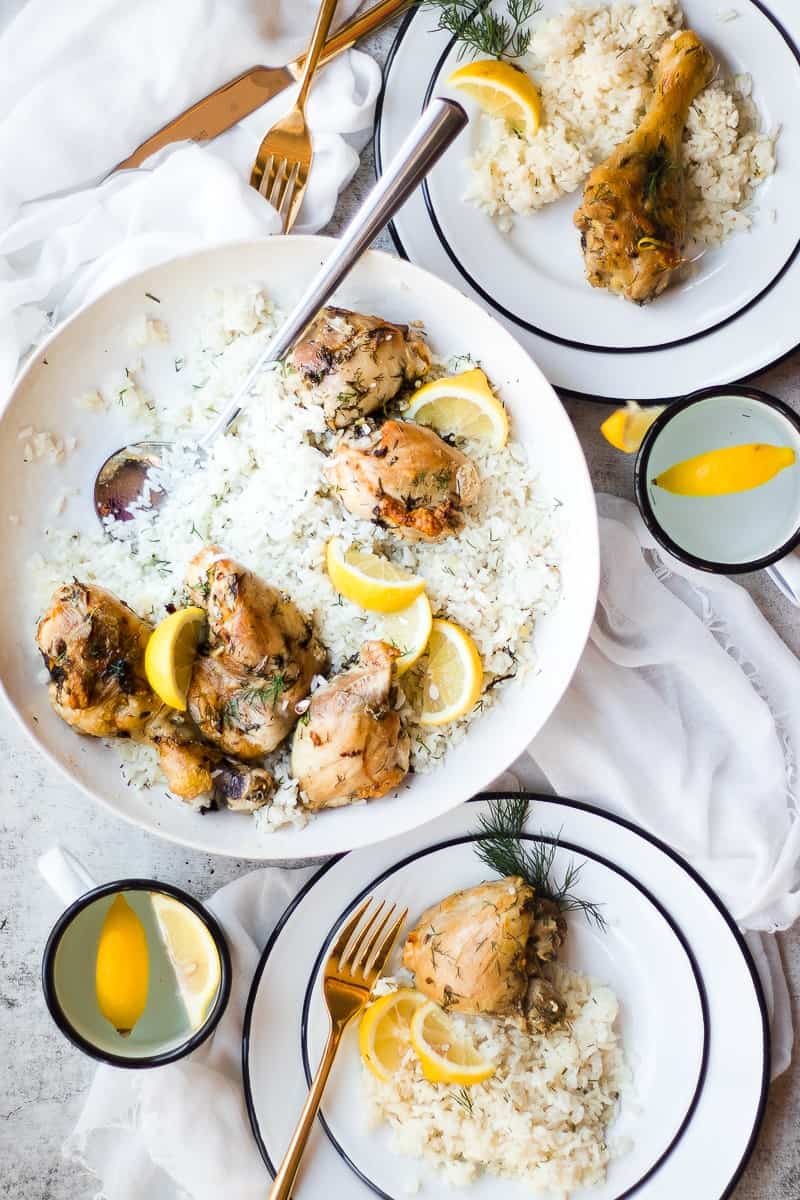 Lemon Herb Chicken and Rice in dish and served on plate with lemon garnish