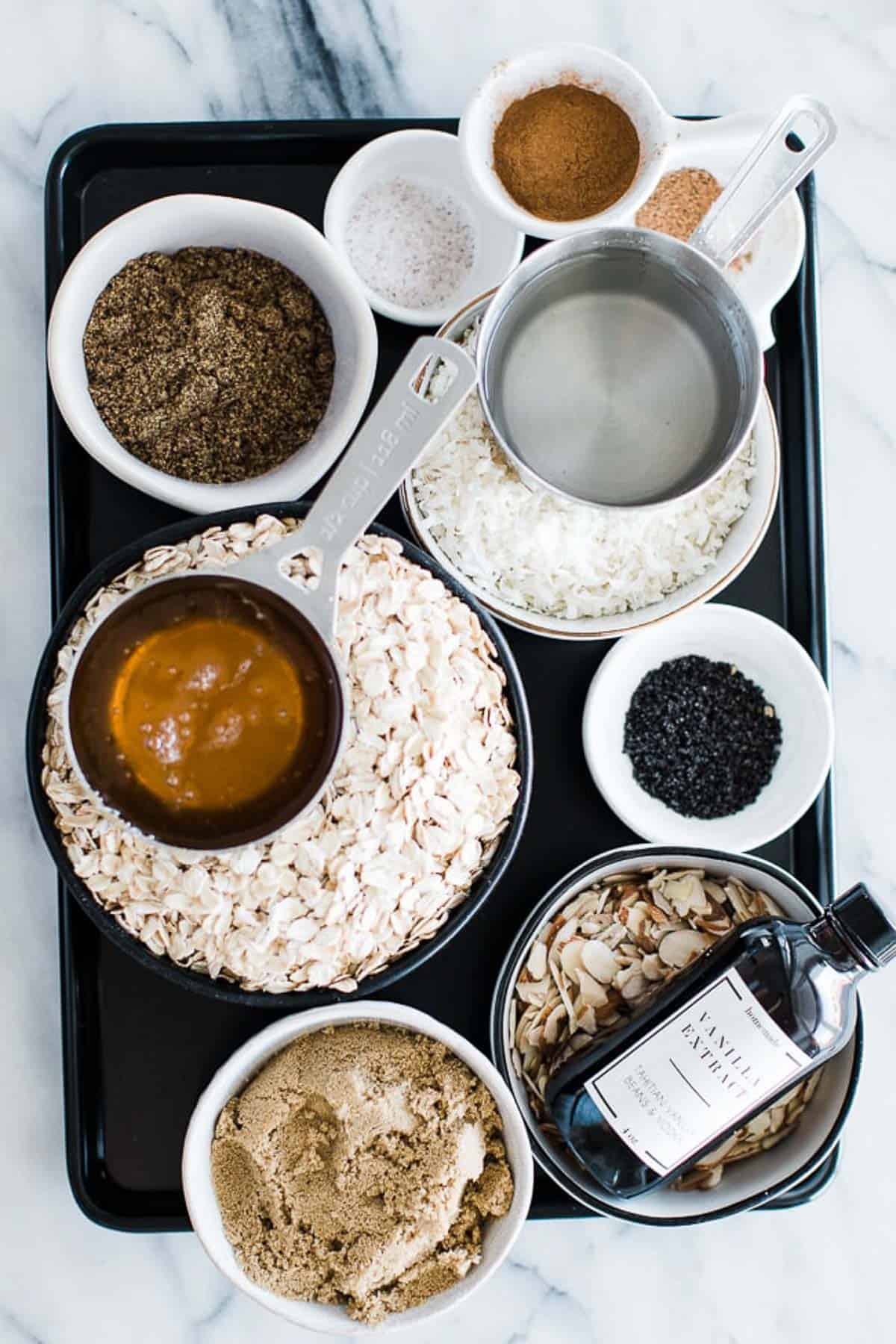 Ingredients to make healthy granola on a tray on the counter.