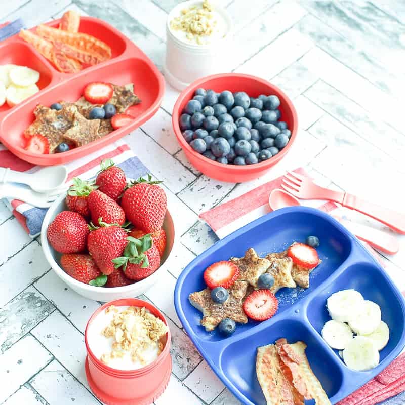 A side shot of children's trays filled with easy french toast, fruit and bacon
