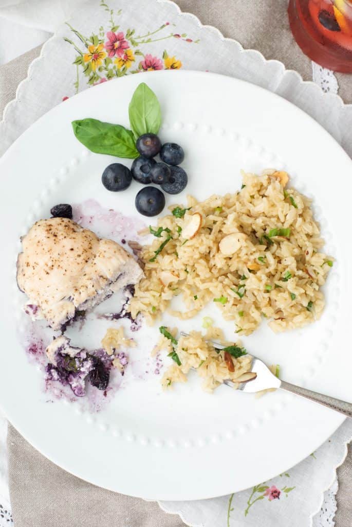 Blueberry Basil Chicken cut in half with Rice Pilaf on a plate