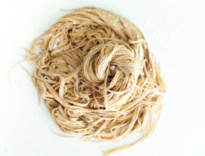 An overhead shot of pasta noodles on a white surface