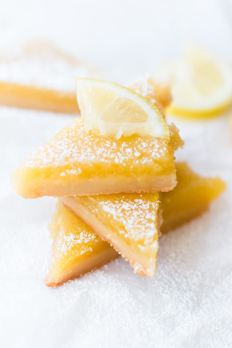 stacked lemon bars with a slice of lemon on top