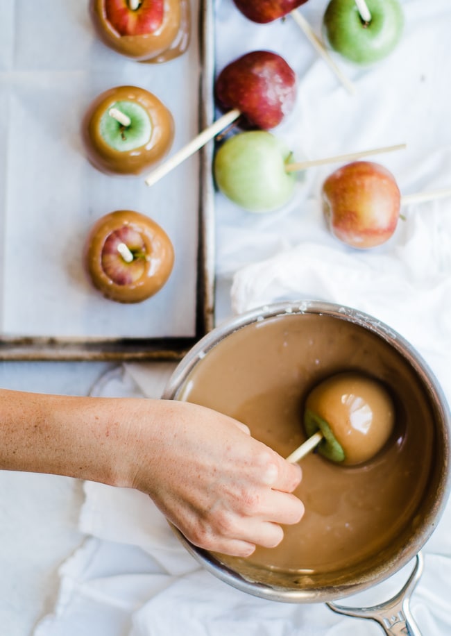 apple being dipped in caramel sauce