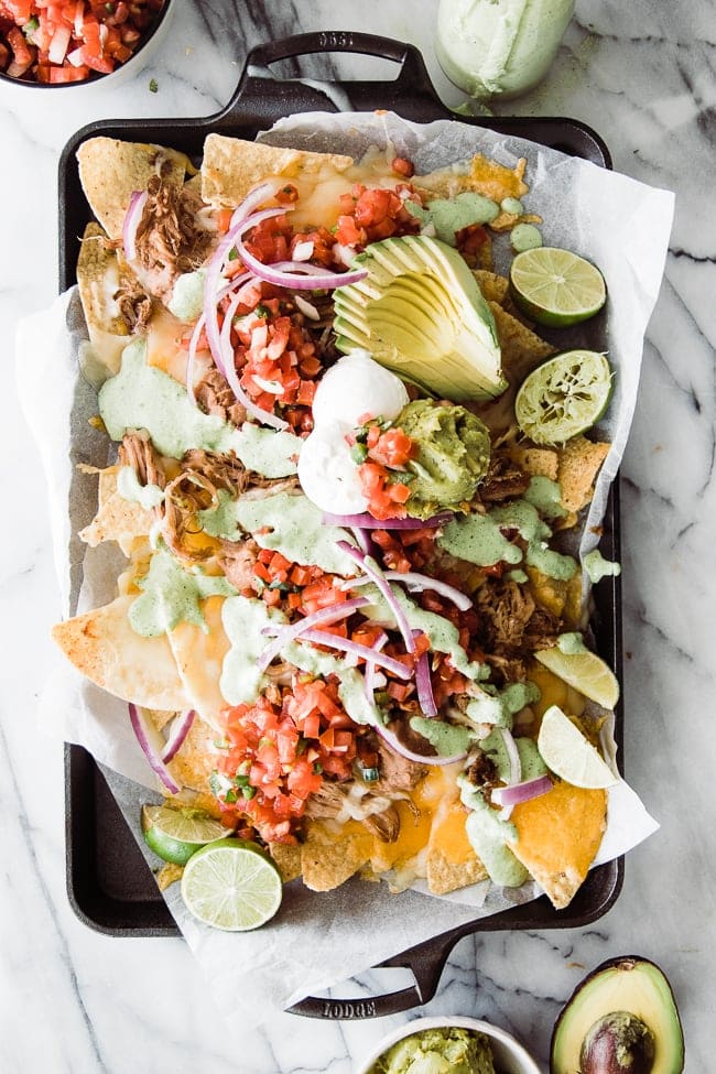 nachos on tray with toppings and creamy jalapeno sauce for super bowl