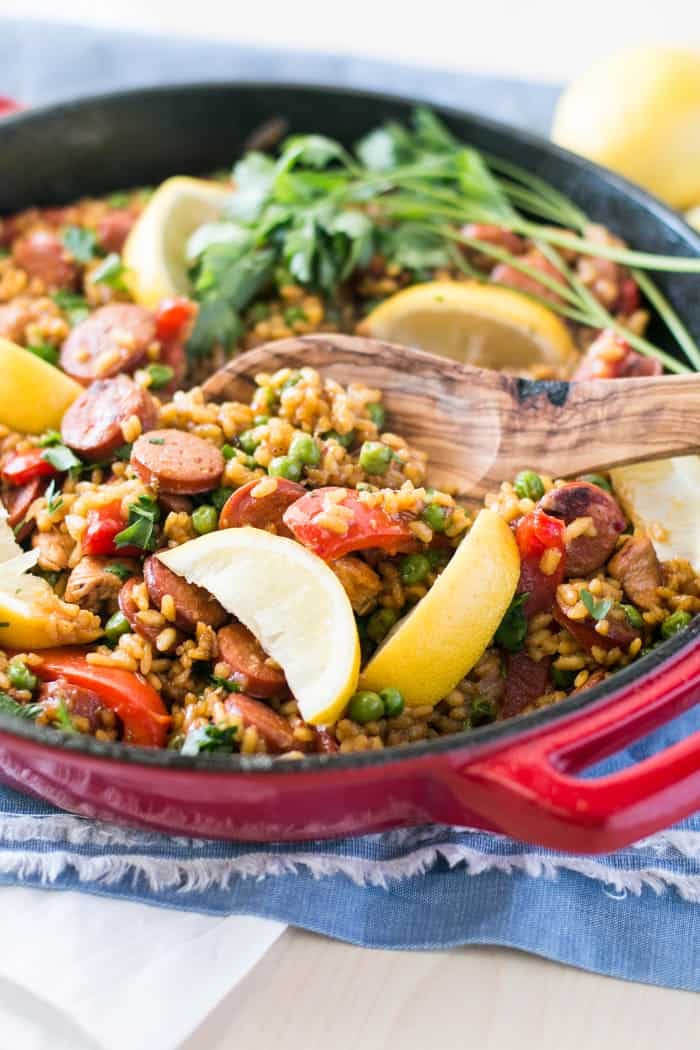 Chicken and Chorizo Paella in pan with wooden spoon 