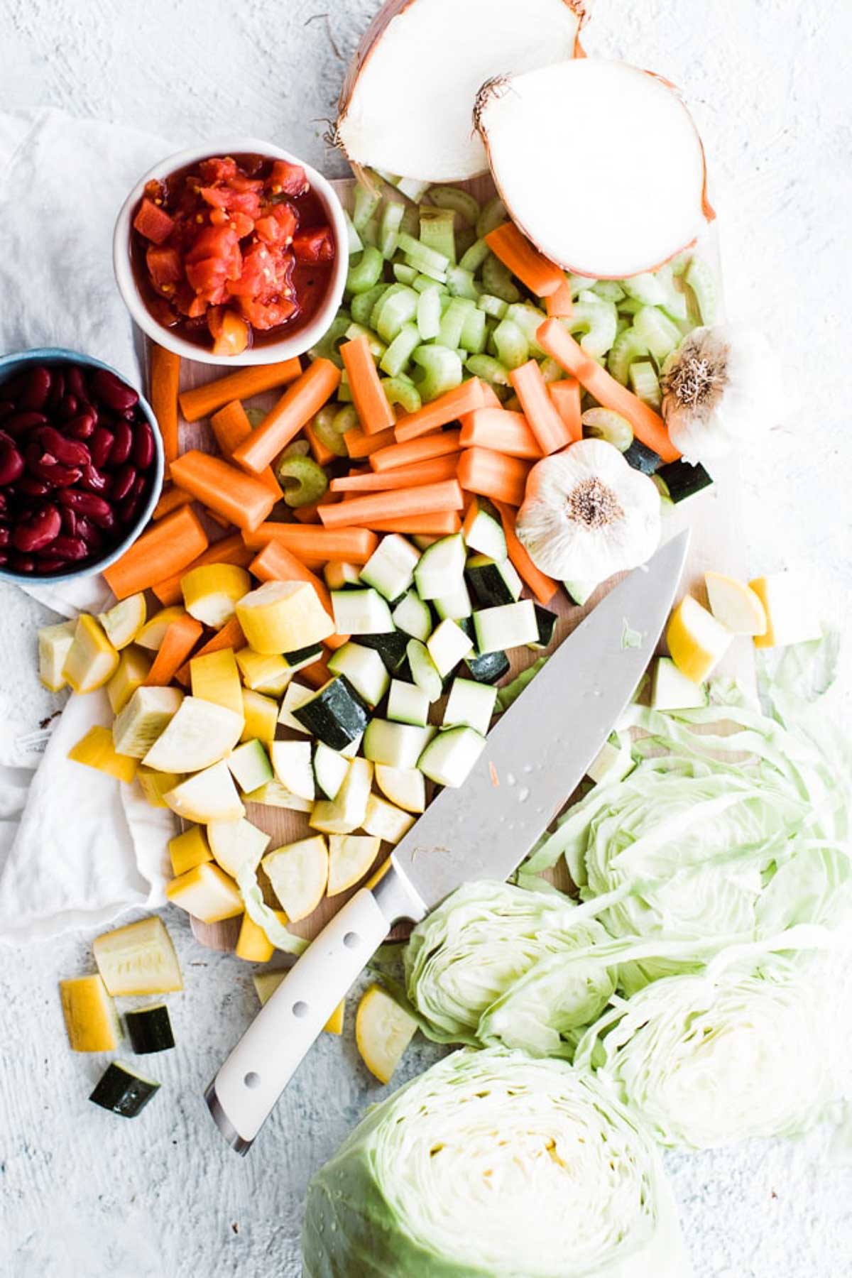 cutting board of chopped veggies with chef knife