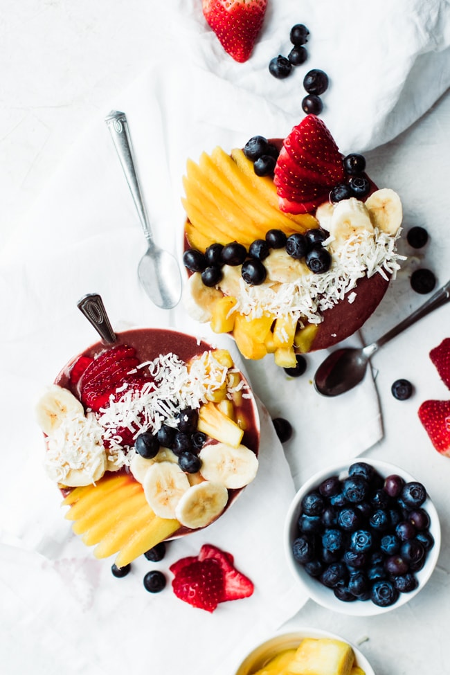 two bowl of acai with fresh fruit, berries and coconut
