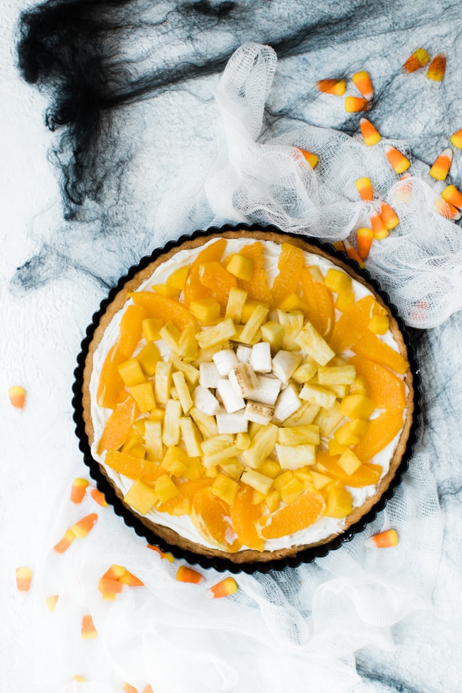 fruit pizza with oranges, mango, pineapple and bananas