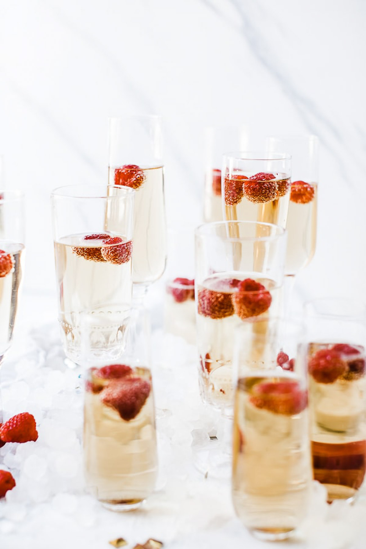 Glasses of nonalcoholic sparkling wine in flutes with raspberries.
