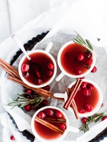 4 cups of cranberry cider with cinnamon sticks as garnish