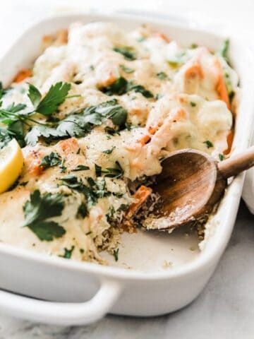 a close up of quinoa bake being scooped out of a casserole dish.