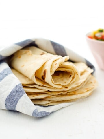 Homemade flour tortillas wrapped in a dish cloth