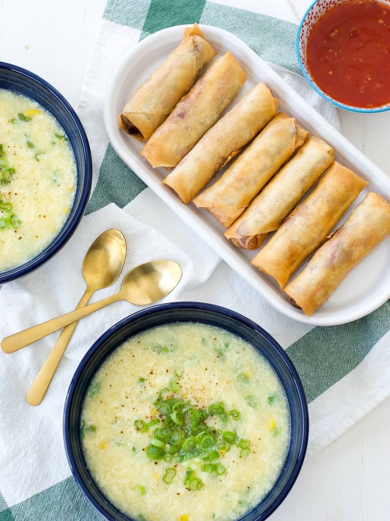 Pork Spring Rolls on platter next to two bowls of soup and dipping sauce
