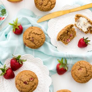 An overhead shot of strawberry bran muffins on white plates