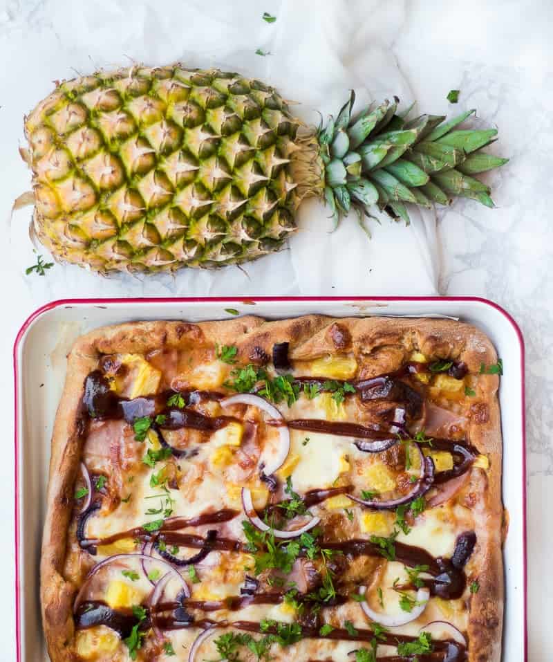 Hawaiian Bacon BBQ Pizza on pan with fresh pineapple 
