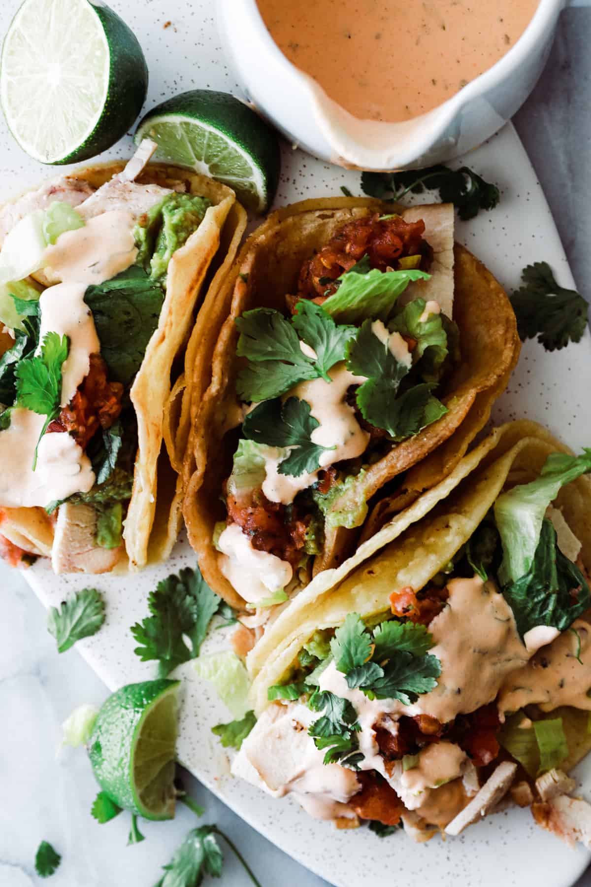 three tacos with creamy chipotle sauce drizzled over