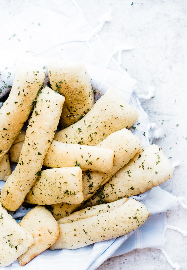 breadsticks in bowl with light blue towel