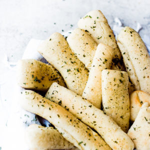bowl of fluffy breadsticks with parsley on top