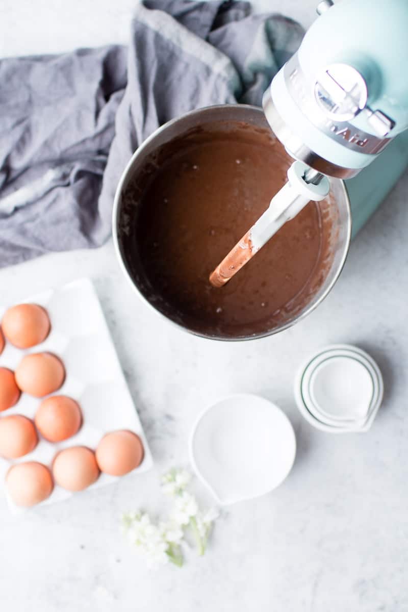 Chocolate Harvest Cake batter in a kitchenaid mixer with fresh eggs to the side