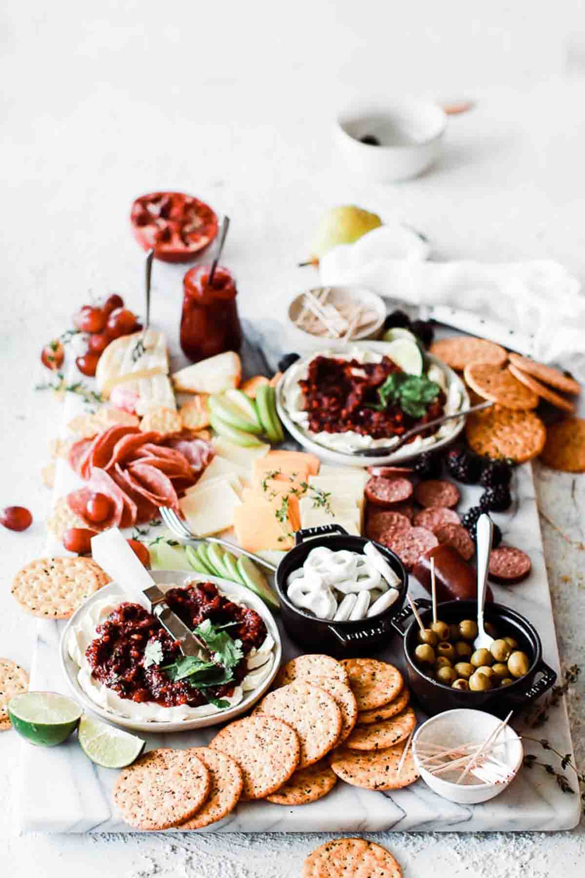 Cheeseboard with cheese, cranberry salsa, apples and crackers.